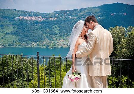 Bride and groom together by an Italian lake View Large Photo Image Picture - Bride and groom together by an Italian lake. Fotosearch