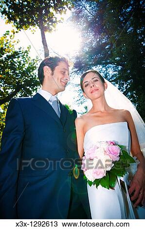 Bride and groom toghether under trees View Large Photo Image Stock Image - Bride and groom toghether under trees. Fotosearch