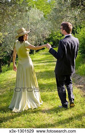 Bride and groom walking through vineyard View Large Photo Image Stock Photo - Bride and groom walking through vineyard. Fotosearch