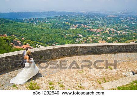 Bride and groom walking together in front of an Italian landscape View Large Photo Image Stock Image - Bride and groom walking together in front of an Italian landscape. Fotosearch