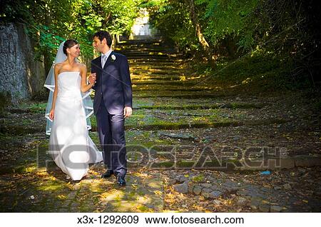 Bride and groom walking toghether in a park View Large Photo Image Stock Photo - Bride and groom walking toghether in a park. Fotosearch
