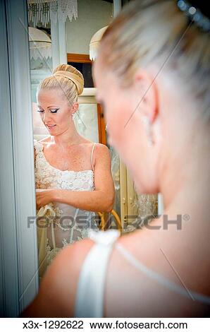 Stock Image - Bride by the mirror getting ready for wedding. Fotosearch