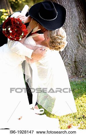 bride & cowboy / groom embraced in a passionate kiss on their wedding day View Large Photo Image Stock Photo - bride & cowboy / groom embraced in a passionate kiss on their wedding day. Fotosearch
