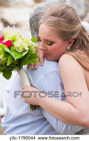 Bride getting a hug from a congratulator right after wedding ceremony View Large Photo Image Picture - Bride getting a hug from a congratulator right after wedding ceremony. Fotosearch