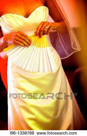 Stock Photo - bride getting ready for wedding holding a fan. Fotosearch