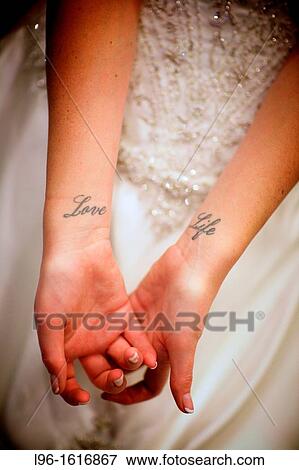 Stock Photo - bride getting ready for wedding showing? love life? tattoo on wrists. Fotosearch