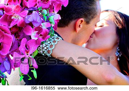 bride groom embracing with bouquet kissing after wedding View Large Photo Image Stock Photography - bride groom embracing with bouquet kissing after wedding. Fotosearch