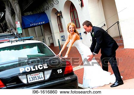 bride groom having fun on street with police car after wedding View Large Photo Image Stock Image - bride groom having fun on street with police car after wedding. Fotosearch