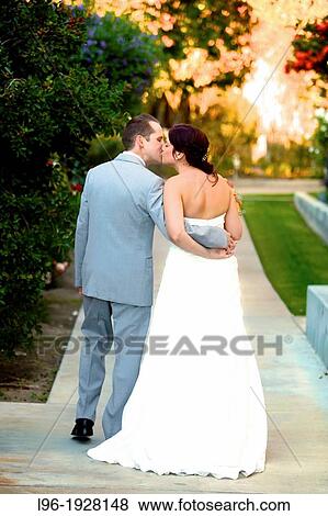 bride & groom stealing a moment alone embraced / kissing after the wedding walking to their bridal suite View Large Photo Image Stock Photo - bride & groom stealing a moment alone embraced / kissing after the wedding walking to their bridal suite. Fotosearch