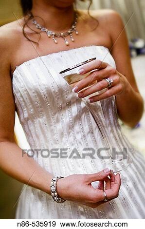 Bride holding a glass of champagne View Large Photo Image Stock Photo - Bride holding a glass of champagne. Fotosearch