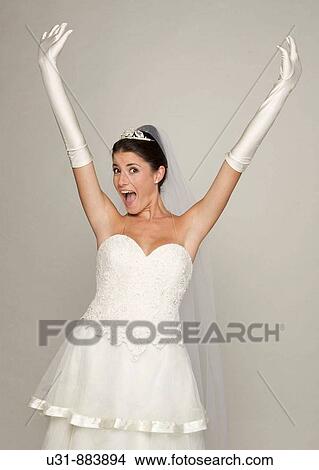 Picture - Bride in her 20s celebrates in a studio setting. Fotosearch