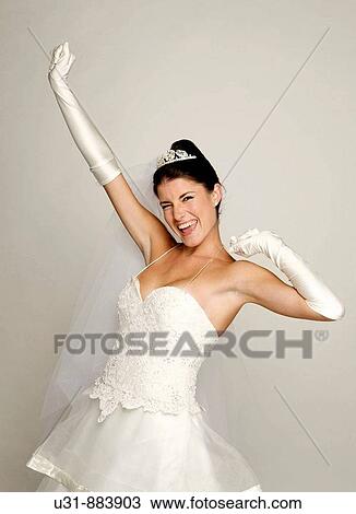 Stock Image - Bride in her 20s celebrates in a studio setting. Fotosearch