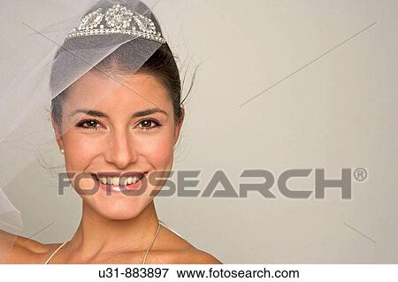 Bride in her 20s discovers herself from under her veil View Large Photo Image Stock Photo - Bride in her 20s discovers herself from under her veil. Fotosearch