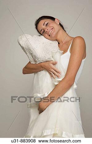 Bride in her 20s hugs her wedding dress View Large Photo Image Stock Photo - Bride in her 20s hugs her wedding dress. Fotosearch