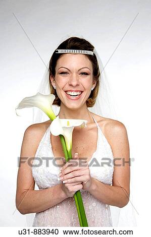 Bride in her 20s smiles at the camera in a studio setting View Large Photo Image Stock Image - Bride in her 20s smiles at the camera in a studio setting. Fotosearch