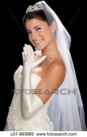 Stock Photo - Bride in her 20s smiles at the camera in a studio setting. Fotosearch