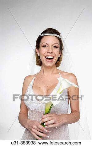 Stock Photo - Bride in her 20s smiles at the camera in a studio setting. Fotosearch