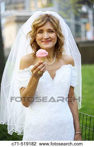 Bride in wedding dress holding ice cream cone View Large Photo Image Stock Image - Bride in wedding dress holding ice cream cone. Fotosearch