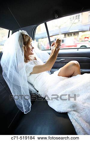 Bride in wedding dress in car taking pictures out the open window View Large Photo Image Picture - Bride in wedding dress in car taking pictures out the open window. Fotosearch