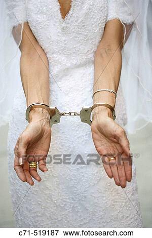 Bride in wedding dress in handcuffs View Large Photo Image Stock Photo - Bride in wedding dress in handcuffs. Fotosearch