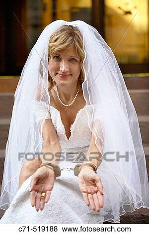 Bride in wedding dress in handcuffs sitting on steps View Large Photo Image Stock Photo - Bride in wedding dress in handcuffs sitting on steps. Fotosearch