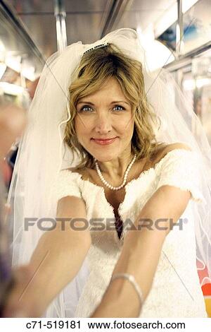 Bride in wedding dress in subway car smiling in camera View Large Photo Image Stock Image - Bride in wedding dress in subway car smiling in camera. Fotosearch