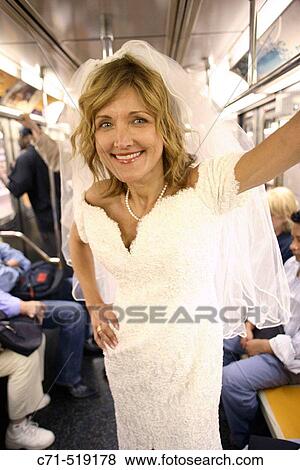 Bride in wedding dress in subway car smiling in camera View Large Photo Image Stock Photo - Bride in wedding dress in subway car smiling in camera. Fotosearch