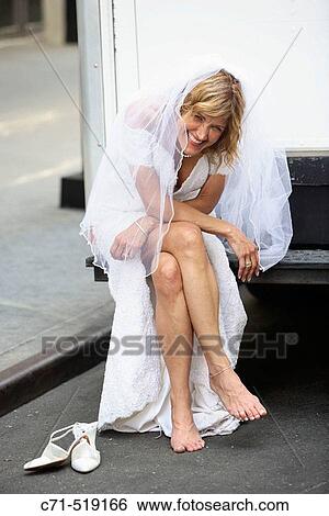 Bride in wedding dress siting on bumper of truck laughing View Large Photo Image Stock Photograph - Bride in wedding dress siting on bumper of truck laughing. Fotosearch