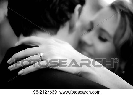 bride kissing groom while showing off her wedding ring View Large Photo Image Stock Photo - bride kissing groom while showing off her wedding ring. Fotosearch