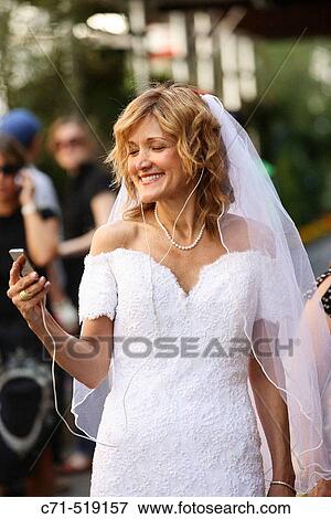Stock Photo - Bride listening and holding ipod. Fotosearch