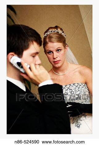 Bride looking at groom on cell phone View Large Photo Image Stock Image - Bride looking at groom on cell phone. Fotosearch