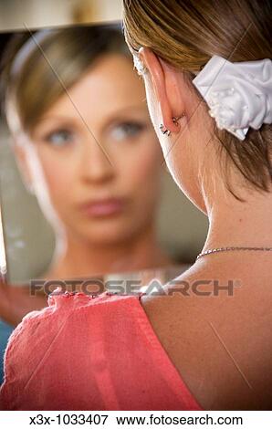 Bride looking in mirror getting ready for wedding View Large Photo Image Stock Photo - Bride looking in mirror getting ready for wedding. Fotosearch