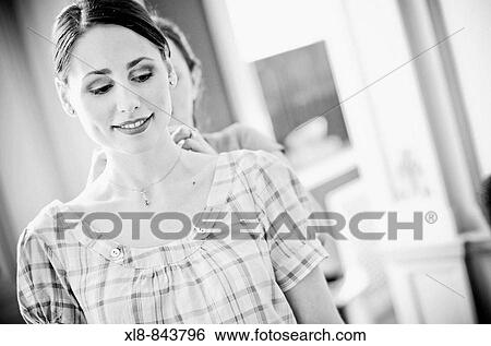 Stock Photograph - bride putting on necklace. Fotosearch