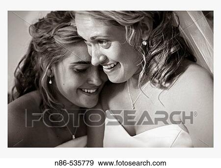 Bride tearing up with bridesmaid View Large Photo Image Stock Photo - Bride tearing up with bridesmaid. Fotosearch
