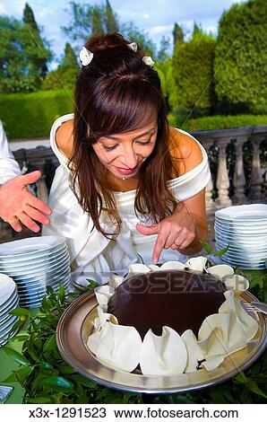 Bride wanting to put her finger in a chocolate wedding cake View Large Photo Image Stock Image - Bride wanting to put her finger in a chocolate wedding cake. Fotosearch