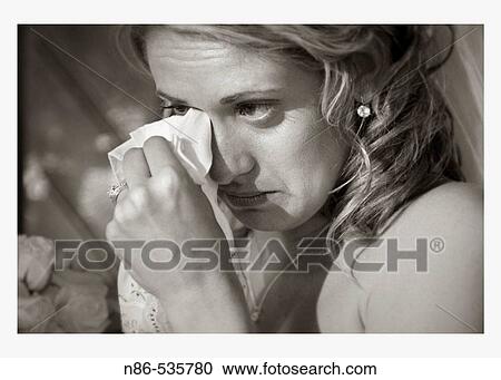 Bride wiping away tears with napkin View Large Photo Image Stock Image - Bride wiping away tears with napkin. Fotosearch