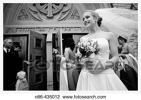 Stock Image - Bride with veil waiting outside of church. Fotosearch