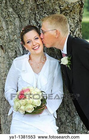 Bridegroom kissing on cheek his bride in park, France View Large Photo Image Stock Image - Bridegroom kissing on cheek his bride in park, France. Fotosearch