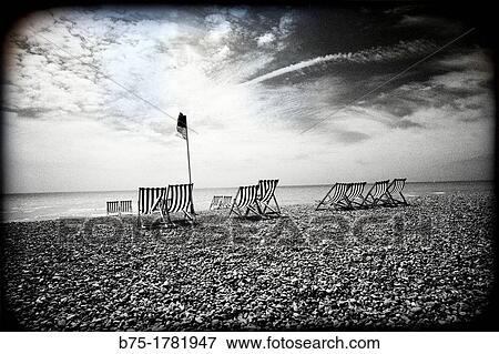 Stock Photo - Brighton, Sussex, England, UK, lonely pebble beach with striped deckchairs,. Fotosearch