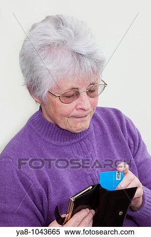 Britain UK Europe Senior woman pulling a Visa credit card from a purse looking serious MR 09/06 View Large Photo Image Stock Photography - Britain UK Europe Senior woman pulling a Visa credit card from a purse looking serious MR 09/06. Fotosearch