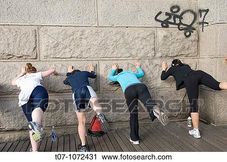 Stock Image - Brooklyn Bridge, New York City, Women streching before excercising,. Fotosearch