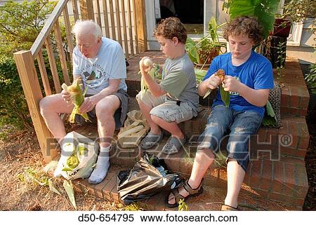 Broomes Island, Maryland. Grandfather and grandsons shucking corn for dinner. View Large Photo Image Stock Photography - Broomes Island, Maryland. Grandfather and grandsons shucking corn for dinner.. Fotosearch