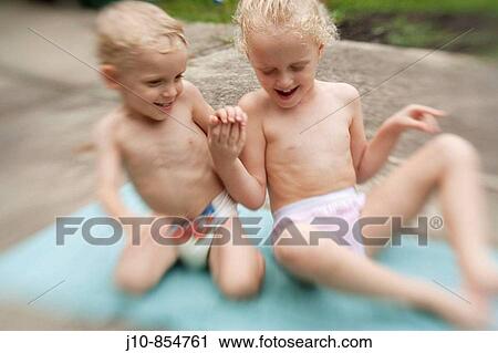 Stock Image - Brother (age 2) and sister (age 5), play on patio in summer, soft-focus effect, Poughkeepsie, New York, USA. Fotosearch