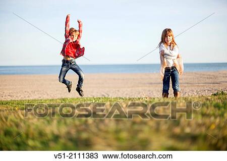 Stock Image - Brother and sister having fun at the beach. Fotosearch