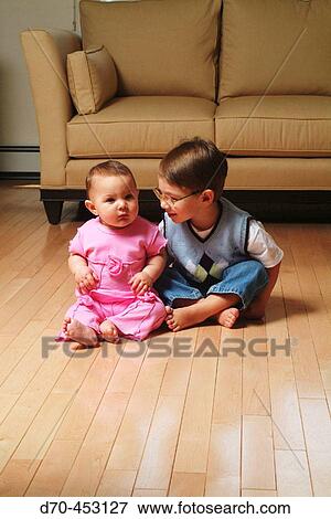 Stock Photo - Brother and sister on livingroom floor. Fotosearch