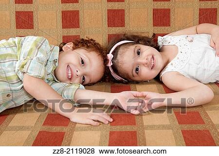 Stock Photo - Brother and sister on the sofa.. Fotosearch