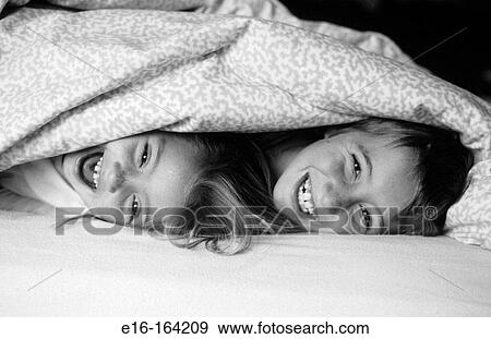 Brother and sister playing in bed covers View Large Photo Image Stock Photo - Brother and sister playing in bed covers. Fotosearch