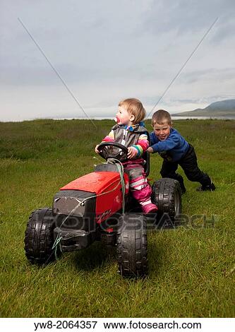 Brother and sister playing on their farmland near Eskifjordur, Iceland. View Large Photo Image Stock Photo - Brother and sister playing on their farmland near Eskifjordur, Iceland.. Fotosearch