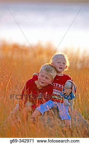 Brother and sister sitting together in evening light. V? sterbotten, Sweden View Large Photo Image Stock Image - Brother and sister sitting together in evening light. V? sterbotten, Sweden. Fotosearch