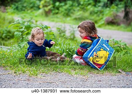 Stock Image - Brother and sister sitting together. Fotosearch